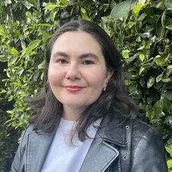 Kyla Gelev, grad student in Pajukanta lab, featured in front of green shrubbery